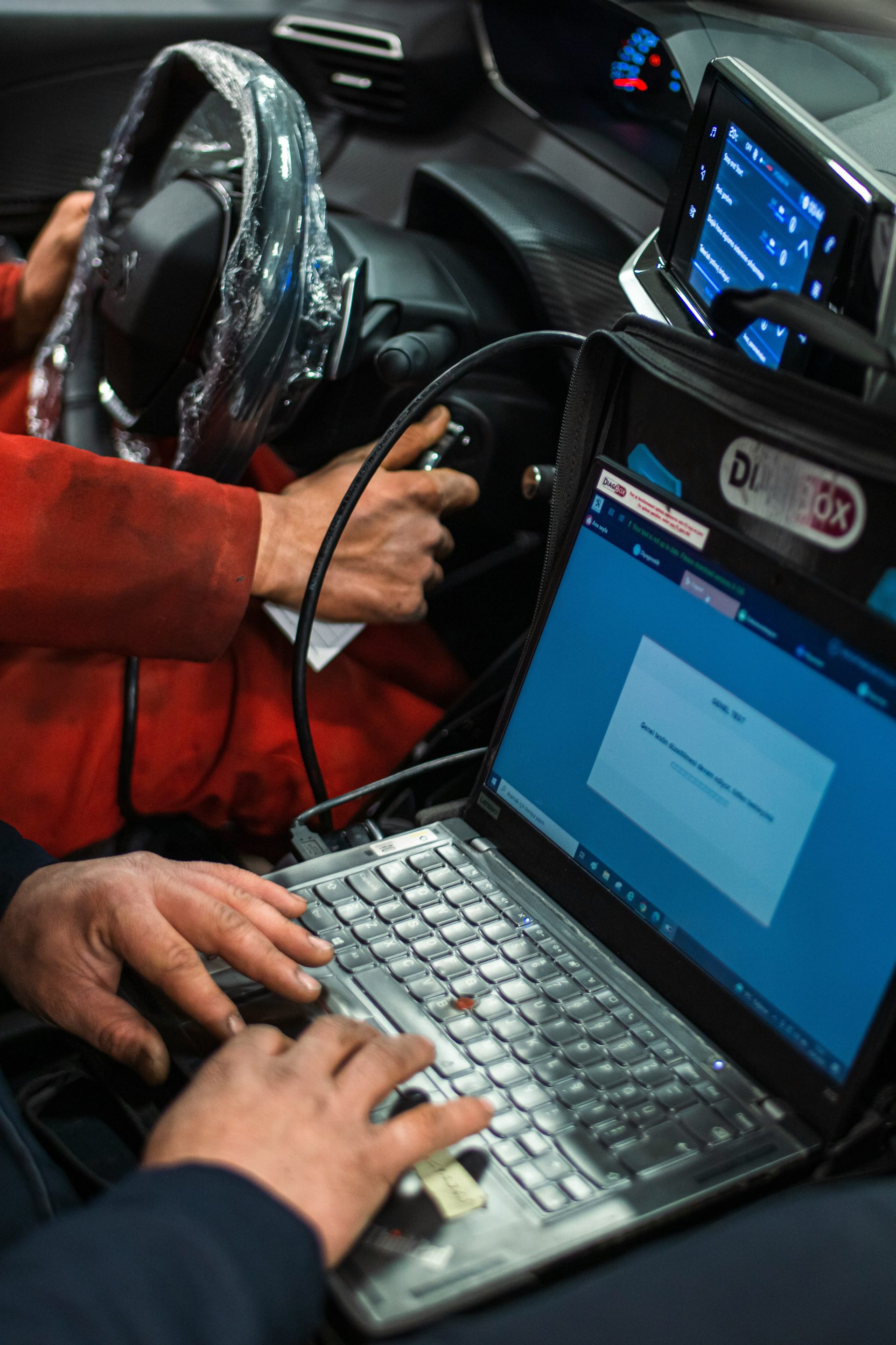 A man sitting in a car using a laptop computer
